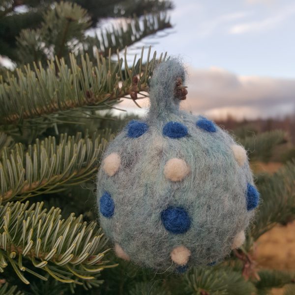 Hand felted Blue Christmas Tree Ball Ornaments by Hillary Dow, Made in Maine, pictured in a tree farm