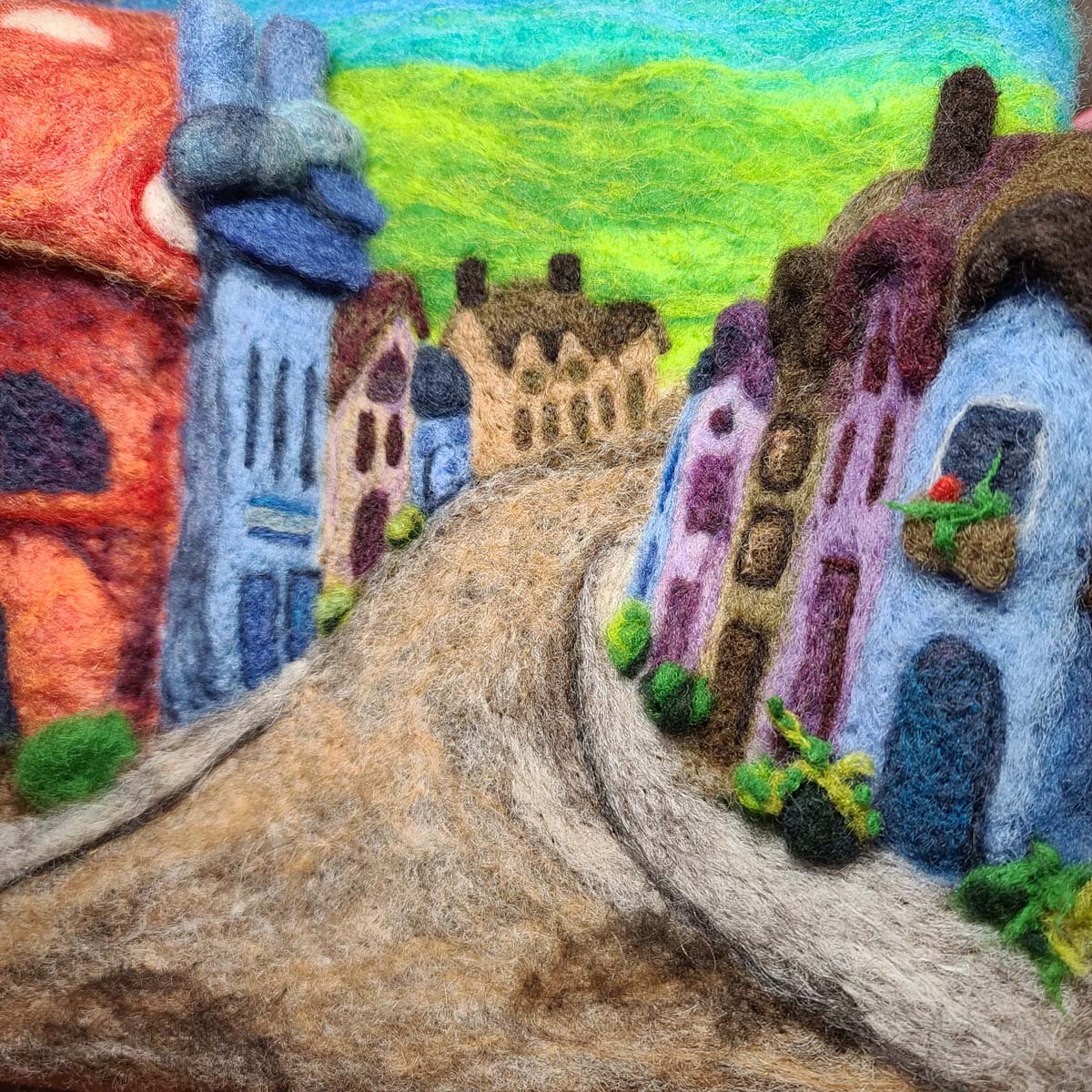 Needle felted village street with plants and planters along the street