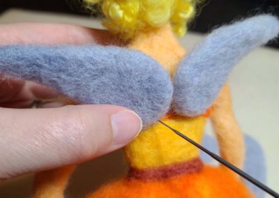 Use your felting needle along the bottom edge and bottom, inner corner of each wing to securely felt the wing into place.