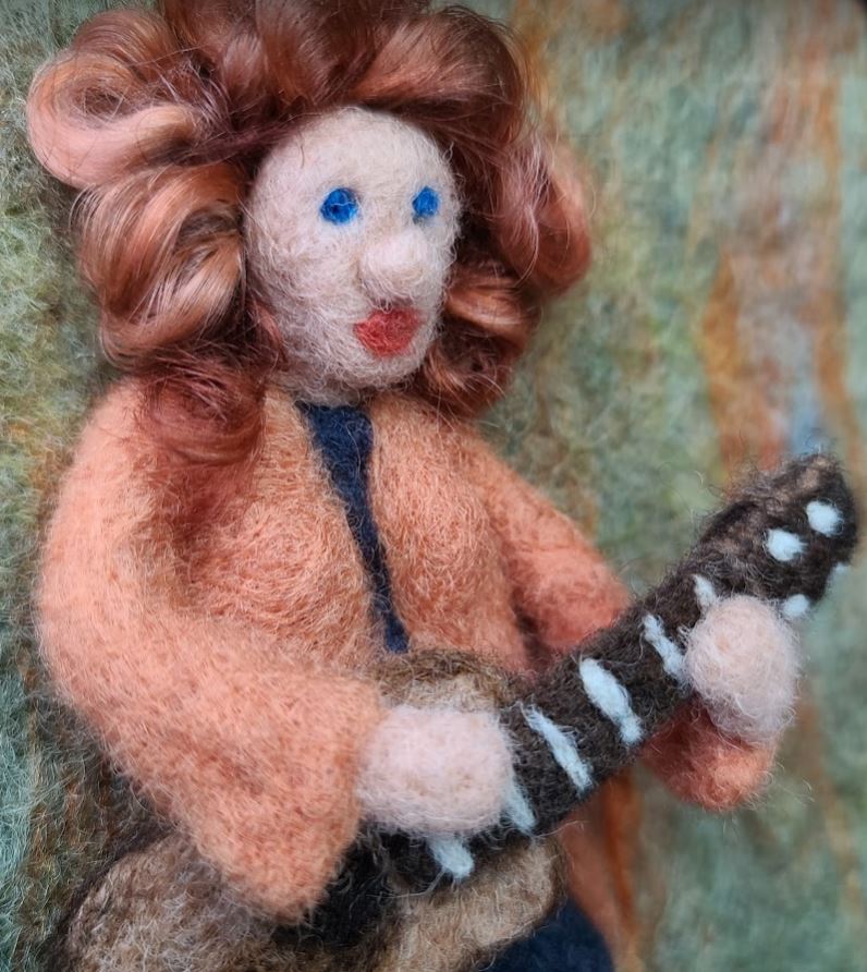 Musician holding a needle felted guitar
